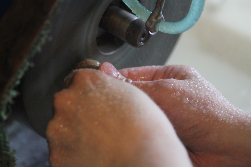 Stone Bilde av steinsliping. Hender holder stein.