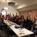 Bilde av ansatte med hendene i været.